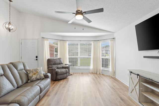 277 Limestone Cir, Crestview, FL 32539 - living room featuring lofted ceiling, a textured ceiling, a chandelier, a ceiling fan, and light wood-type flooring