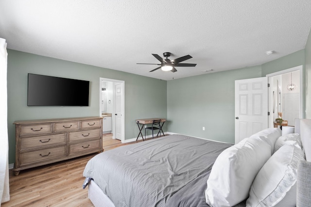 277 Limestone Cir, Crestview, FL 32539 - bedroom featuring light wood-style floors, a textured ceiling, ceiling fan, and ensuite bath