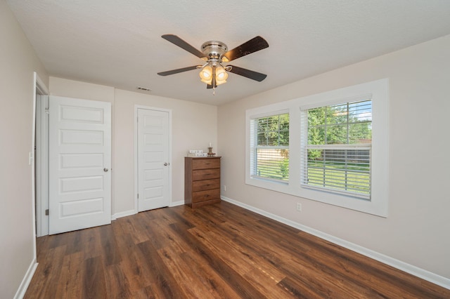 379 W 1st Ave, Crestview, FL 32536 - unfurnished bedroom with dark wood-style flooring, ceiling fan, and a closet
