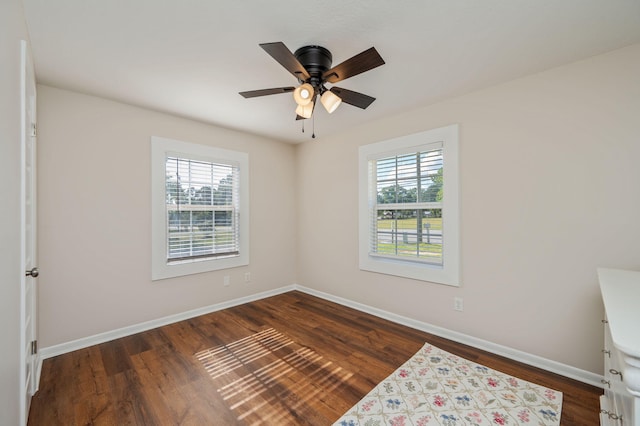 379 W 1st Ave, Crestview, FL 32536 - unfurnished bedroom featuring multiple windows, dark wood finished floors, and ceiling fan
