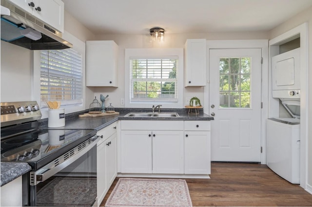 379 W 1st Ave, Crestview, FL 32536 - kitchen with stainless steel electric stove, estacked washer and dryer, under cabinet range hood, and plenty of natural light
