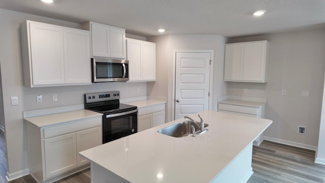 4408 Marine Loop, Crestview, FL 32539 - kitchen featuring range with electric stovetop, wood finished floors, stainless steel microwave, white cabinetry, and recessed lighting