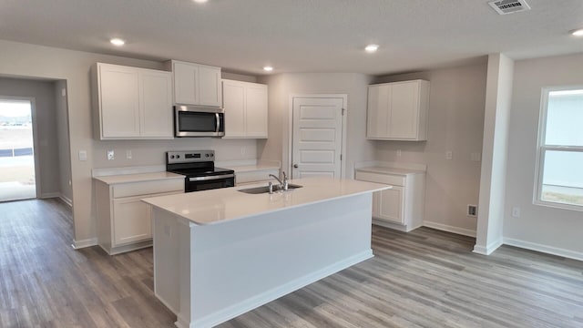 4408 Marine Loop, Crestview, FL 32539 - kitchen featuring range with electric cooktop, stainless steel microwave, light wood finished floors, white cabinets, and light countertops