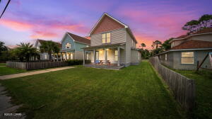 6320 N Lagoon Dr, Panama City Beach, FL 32408 - back of house at dusk featuring a fenced backyard