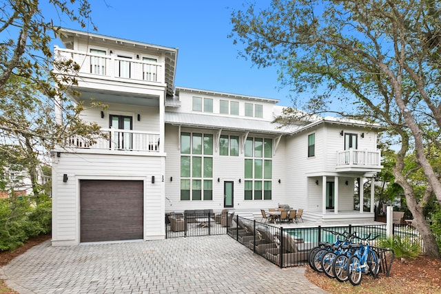 12 Seabreeze Way, Inlet Beach, FL 32461 - back of house featuring a balcony, a garage, decorative driveway, and a patio area