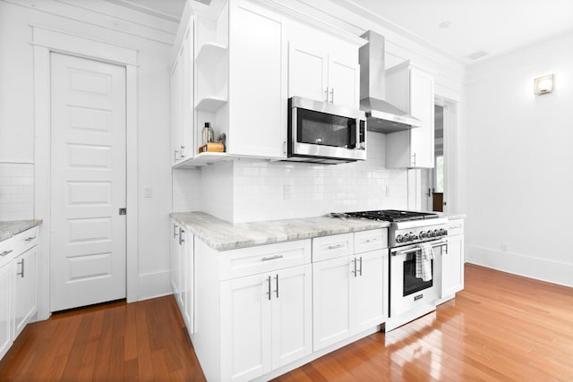 12 Seabreeze Way, Inlet Beach, FL 32461 - kitchen featuring open shelves, wall chimney exhaust hood, appliances with stainless steel finishes, and light wood-type flooring