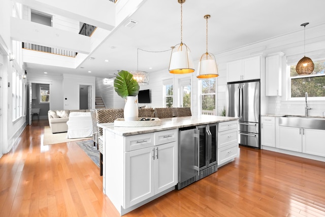 12 Seabreeze Way, Inlet Beach, FL 32461 - kitchen featuring open floor plan, decorative backsplash, freestanding refrigerator, white cabinetry, and light wood-style flooring