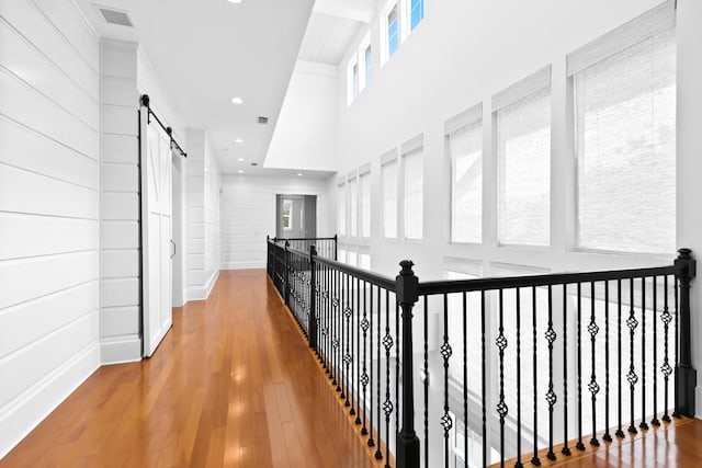12 Seabreeze Way, Inlet Beach, FL 32461 - hall featuring a barn door, a high ceiling, wood finished floors, and recessed lighting