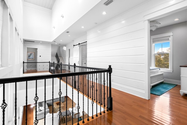 12 Seabreeze Way, Inlet Beach, FL 32461 - corridor featuring a barn door, wood finished floors, an upstairs landing, and recessed lighting
