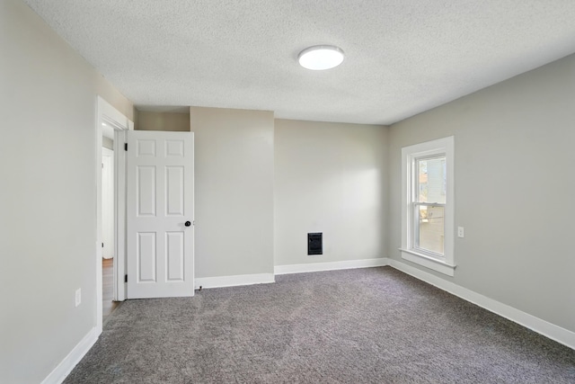 empty room with baseboards, carpet, and a textured ceiling