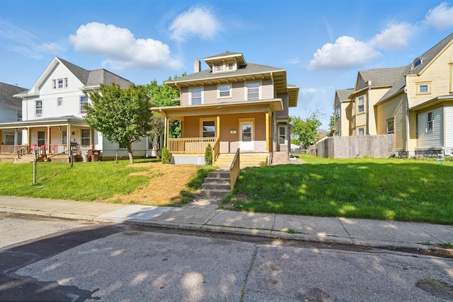 view of front of property with a residential view, fence, covered porch, and a front lawn