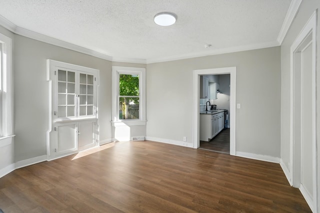 interior space with crown molding, a textured ceiling, dark wood-type flooring, and visible vents