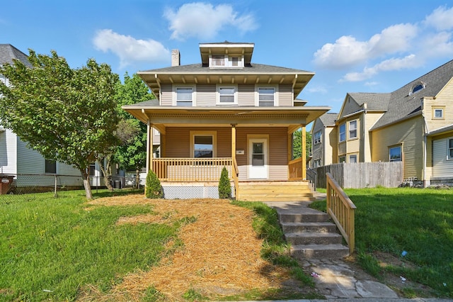 traditional style home featuring a front lawn, fence, and covered porch