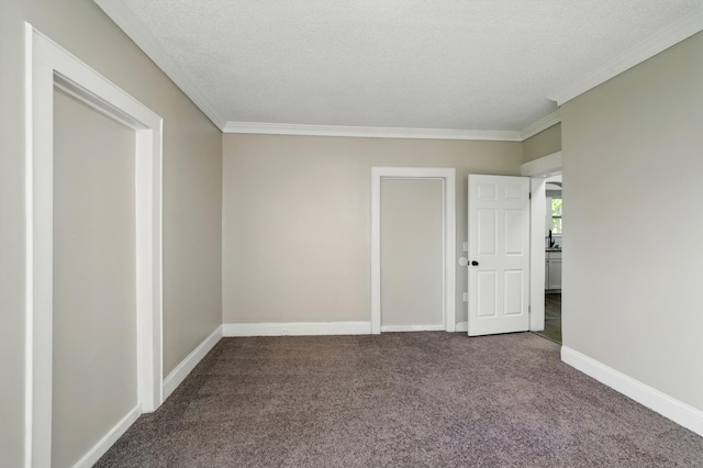 spare room with crown molding, baseboards, carpet flooring, and a textured ceiling