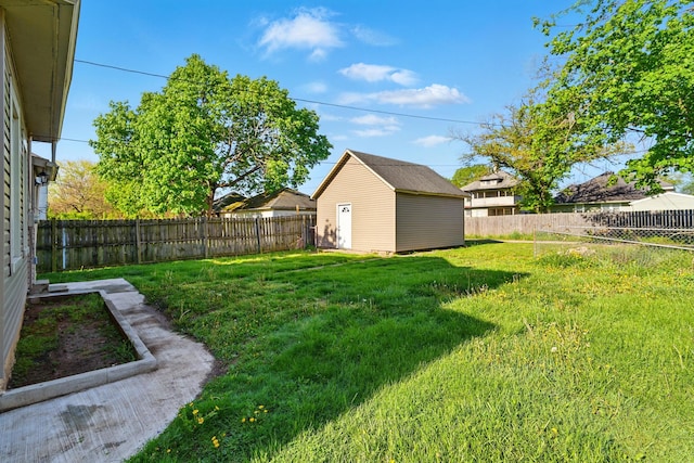 view of yard with an outdoor structure, a fenced backyard, and a storage unit