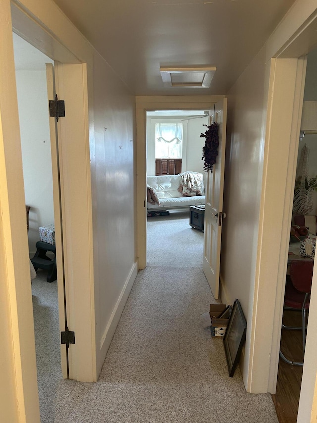 hallway featuring light colored carpet