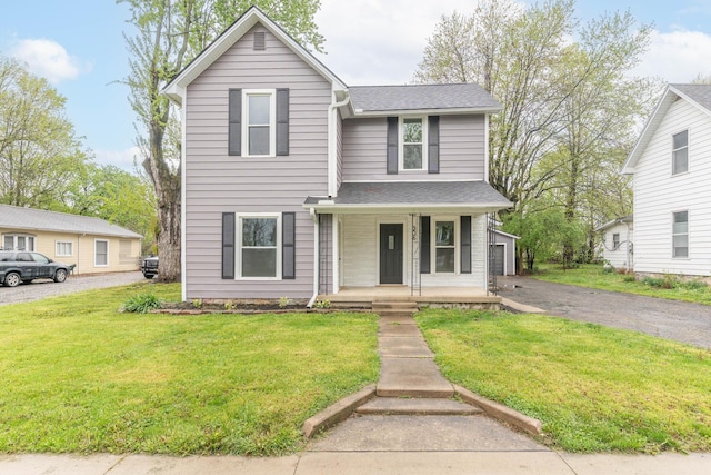 traditional-style home with a porch, a front lawn, and a shingled roof