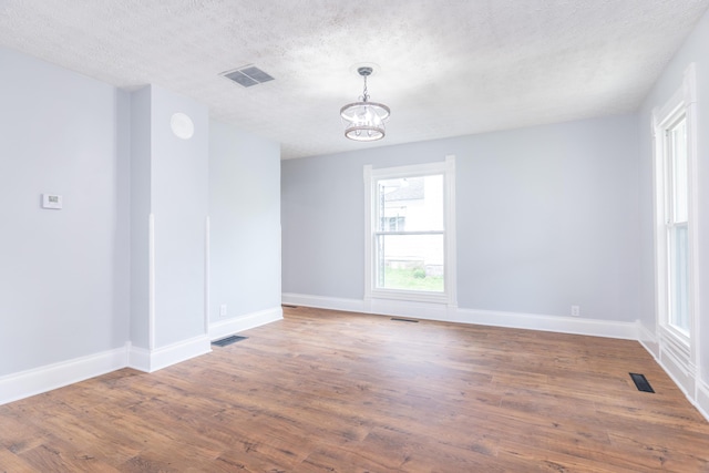 unfurnished room with an inviting chandelier and visible vents