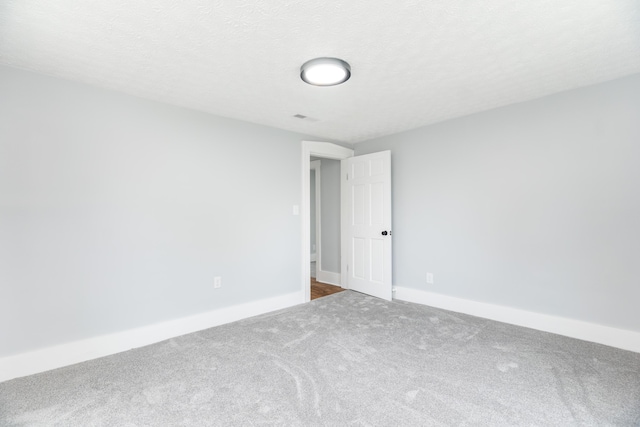 carpeted empty room featuring visible vents and baseboards