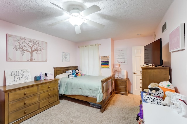 carpeted bedroom with ceiling fan and a textured ceiling