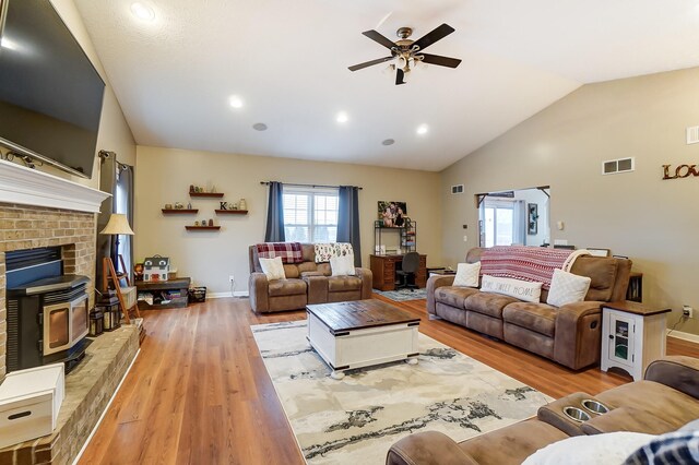 living room featuring ceiling fan, lofted ceiling, and light hardwood / wood-style floors