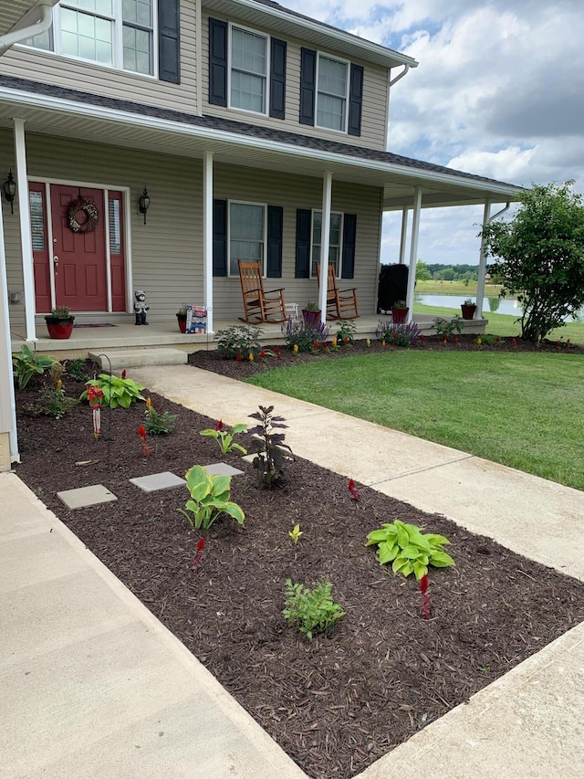 farmhouse with covered porch and a front yard