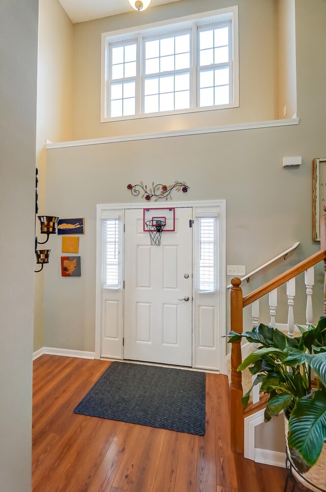 foyer entrance featuring hardwood / wood-style flooring and a towering ceiling