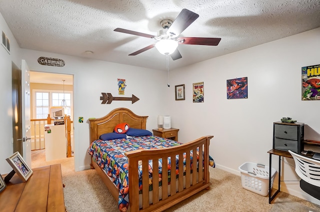 carpeted bedroom with ceiling fan and a textured ceiling