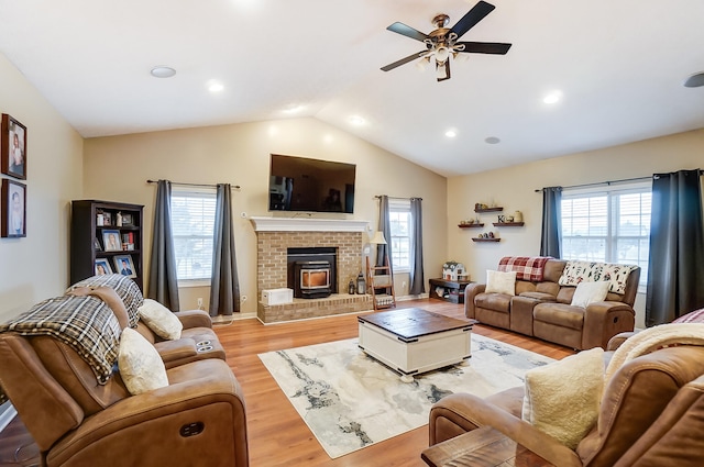 living room with light wood-type flooring, lofted ceiling, and a wealth of natural light