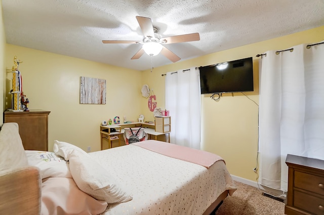 carpeted bedroom with ceiling fan and a textured ceiling