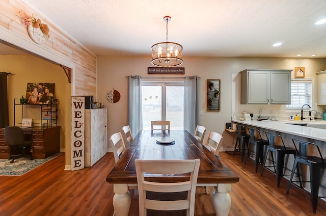 dining area featuring a notable chandelier, dark wood-type flooring, and a wealth of natural light