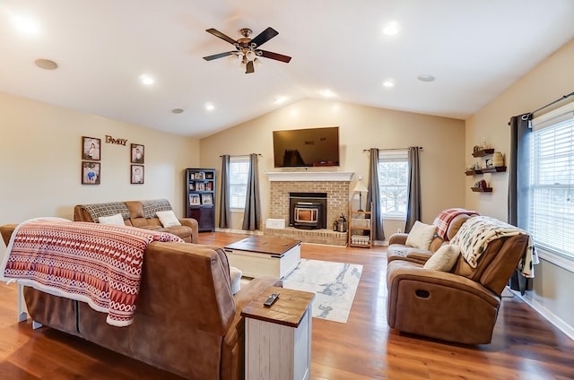 living room featuring hardwood / wood-style flooring, ceiling fan, vaulted ceiling, and a wealth of natural light