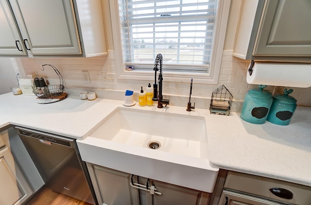 kitchen featuring gray cabinetry, tasteful backsplash, and dishwasher