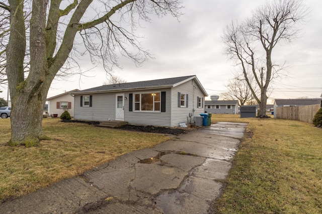 view of front of house with a front yard and fence