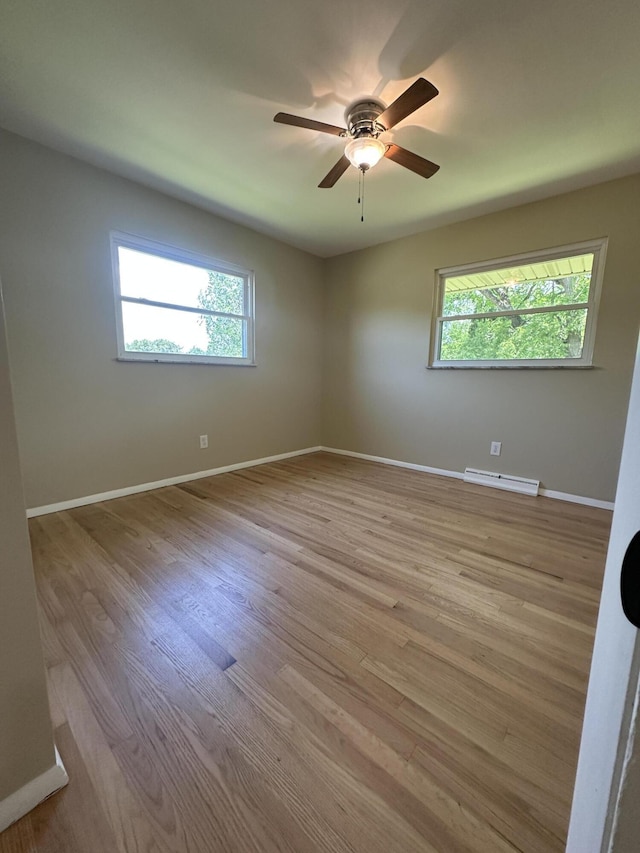 2336 Derr Rd, Springfield, OH 45503 - unfurnished room featuring healthy amount of natural light, wood finished floors, a ceiling fan, and a baseboard heating unit