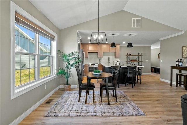 dining area with vaulted ceiling, light wood-style flooring, visible vents, and baseboards