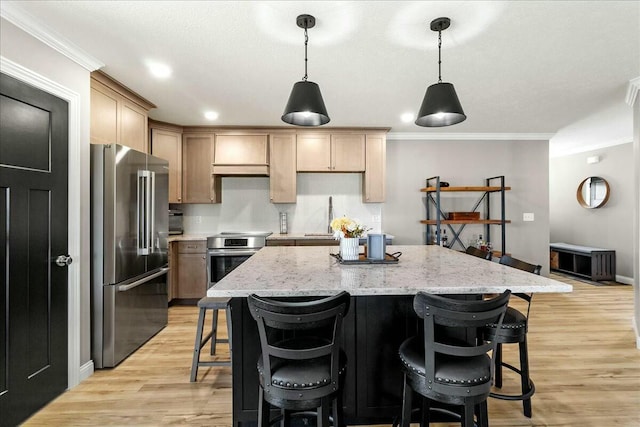 kitchen featuring high quality fridge, stove, a breakfast bar area, and light wood-style floors