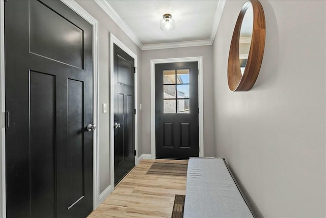 doorway featuring light wood-style floors, baseboards, and ornamental molding