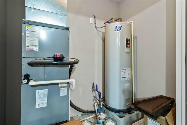 utility room with heating unit and electric water heater