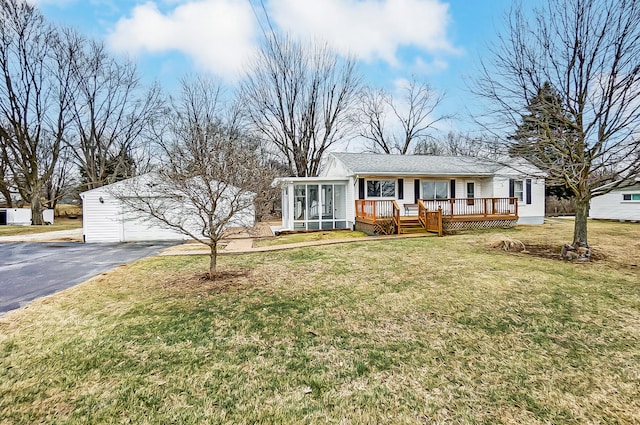 ranch-style home featuring a garage, a sunroom, and a front lawn