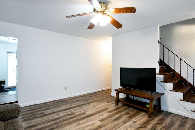 living room featuring baseboards, a ceiling fan, stairs, and wood finished floors