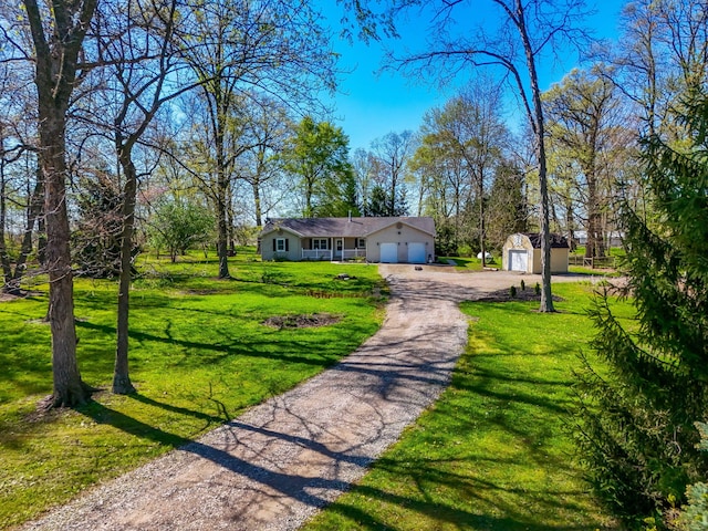 11851 Sanders Rd, Richwood, OH 43344 - view of front of home featuring an attached garage, an outbuilding, a front lawn, and driveway
