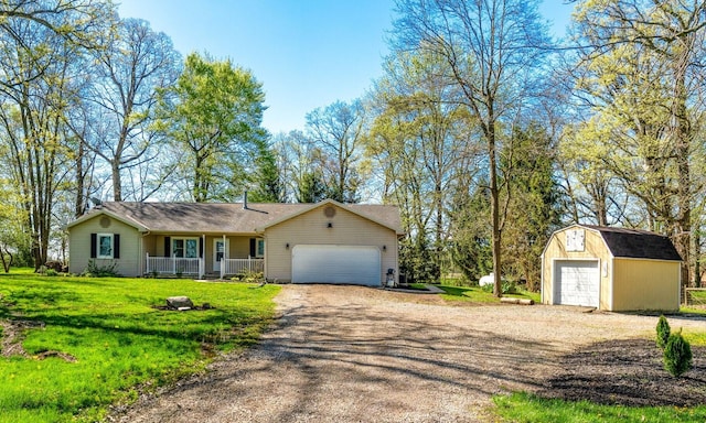 11851 Sanders Rd, Richwood, OH 43344 - view of front of property with covered porch, a front yard, dirt driveway, an outbuilding, and an attached garage