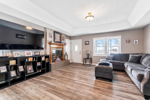 11851 Sanders Rd, Richwood, OH 43344 - living area featuring a tiled fireplace, a raised ceiling, baseboards, and wood finished floors