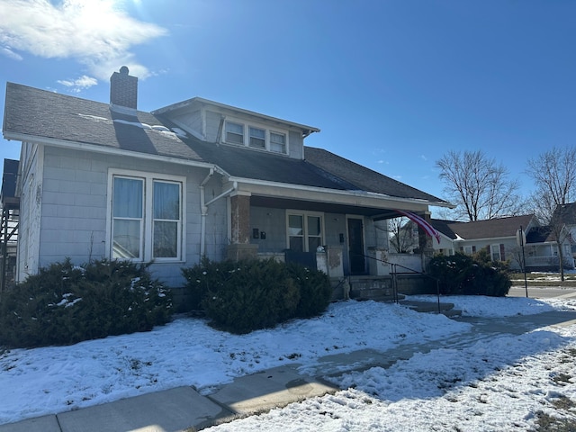 bungalow-style house with covered porch and a chimney