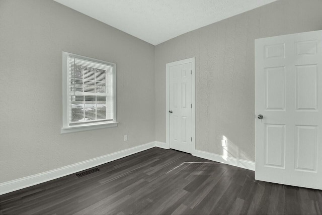 spare room with dark wood-type flooring