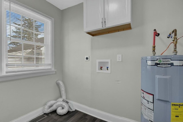 laundry room featuring cabinets, dark hardwood / wood-style flooring, water heater, and electric dryer hookup