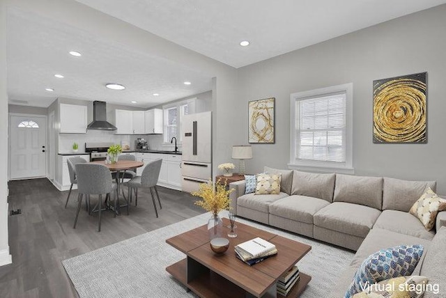 living room featuring plenty of natural light, light hardwood / wood-style floors, and sink