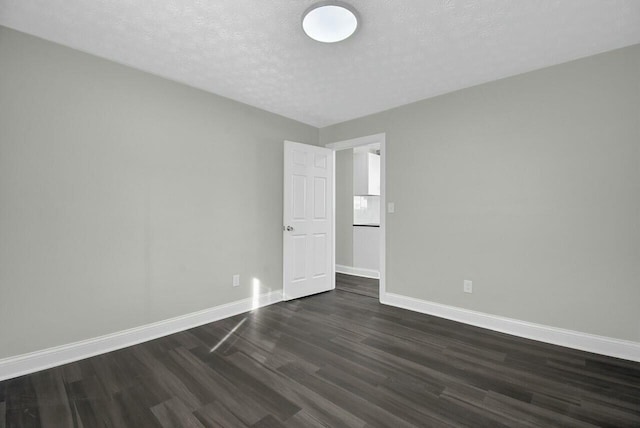 empty room featuring dark hardwood / wood-style floors and a textured ceiling