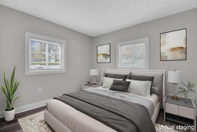 bedroom featuring multiple windows, dark hardwood / wood-style floors, and a textured ceiling